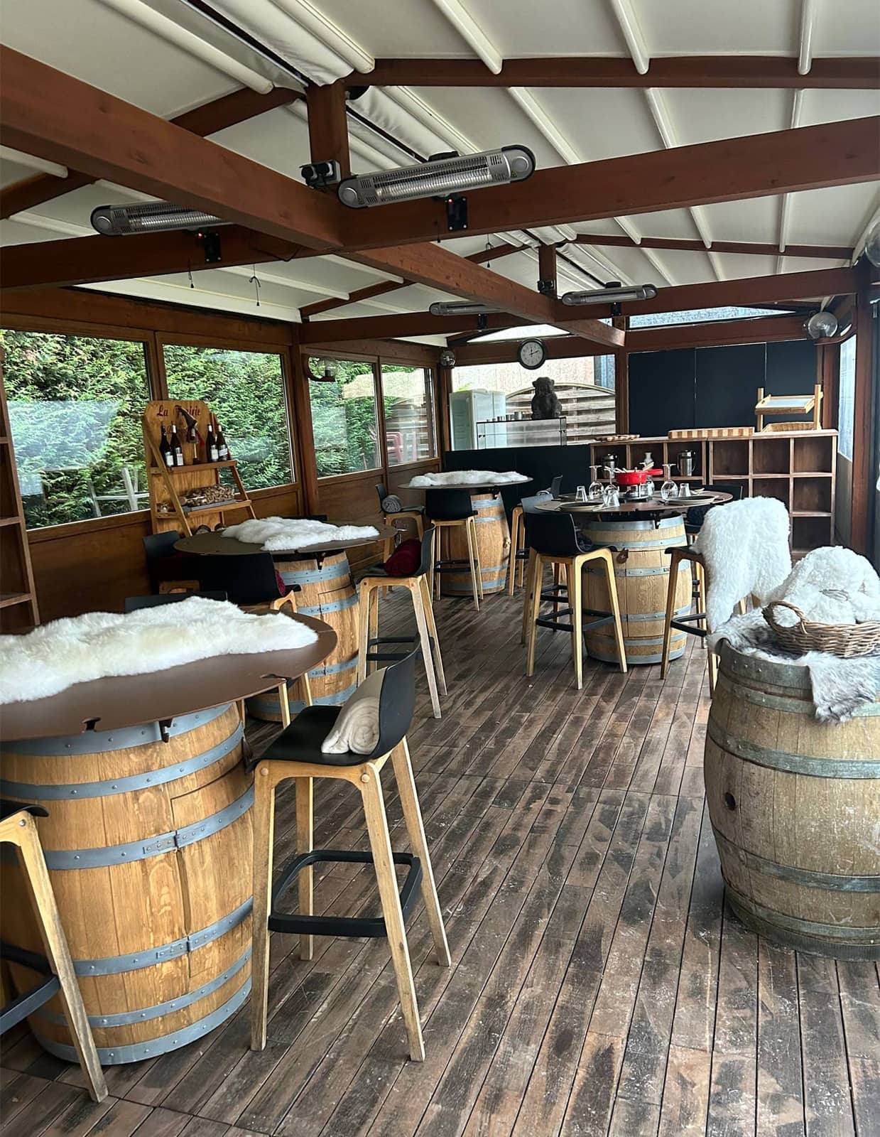 La salle rustique-chic de La Table d'Alex à Étupes : tonneaux, bar bleu marine et baies vitrées